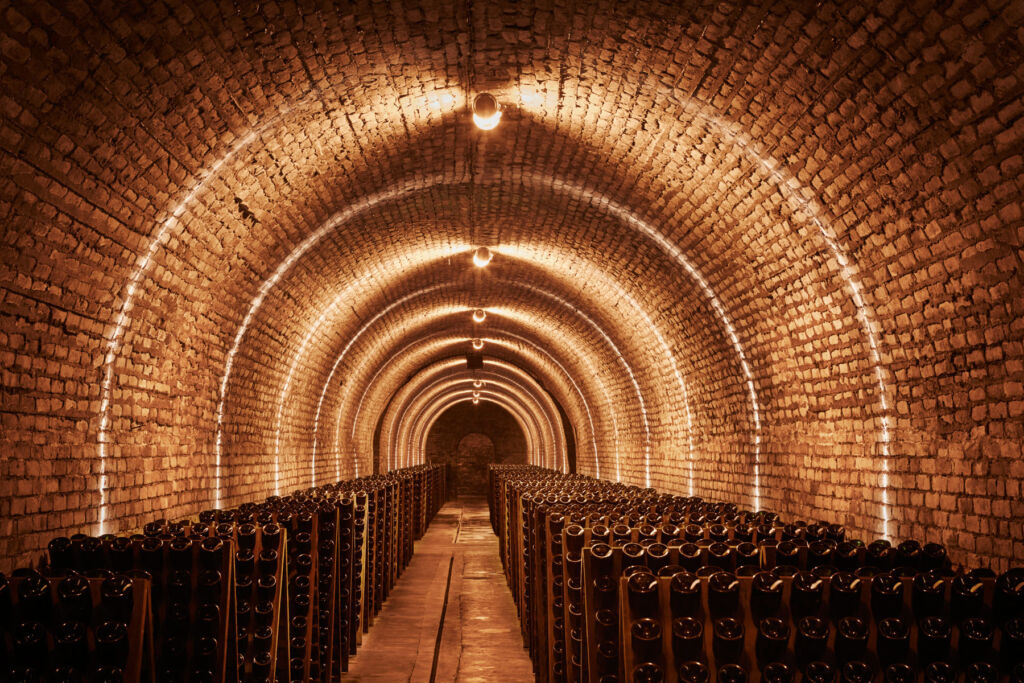 Inside one of the huge wine cellars with thousands of stacked bottles
