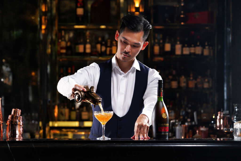 A bartender pouring the Side Car cocktail