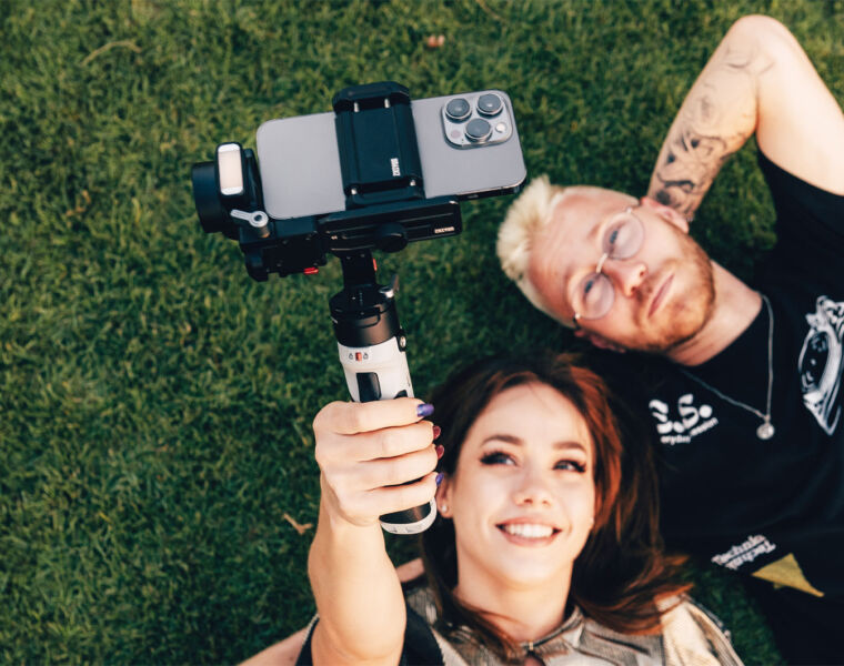 A couple laying on the grass using the Zhiyun Crane-M2 S