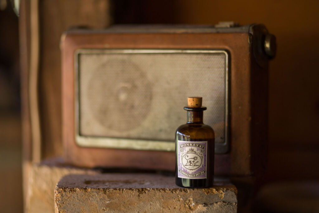 A mini bottle of Monkey 47 Gin in front of a vintage transistor radio