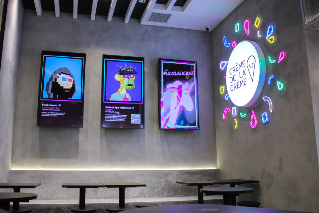 The screens inside the ice cream parlour displaying NFT artworks