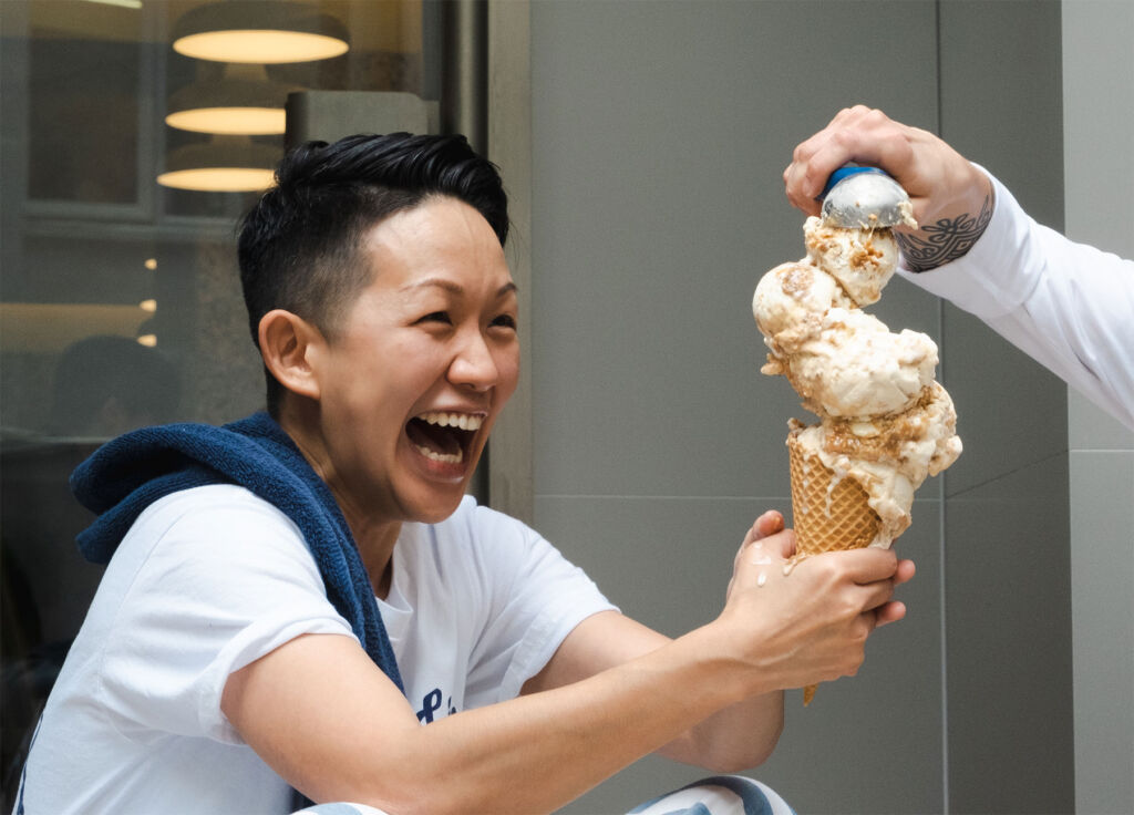 A very excited Chef May Chow holding a super-sized cone filled with Gelato