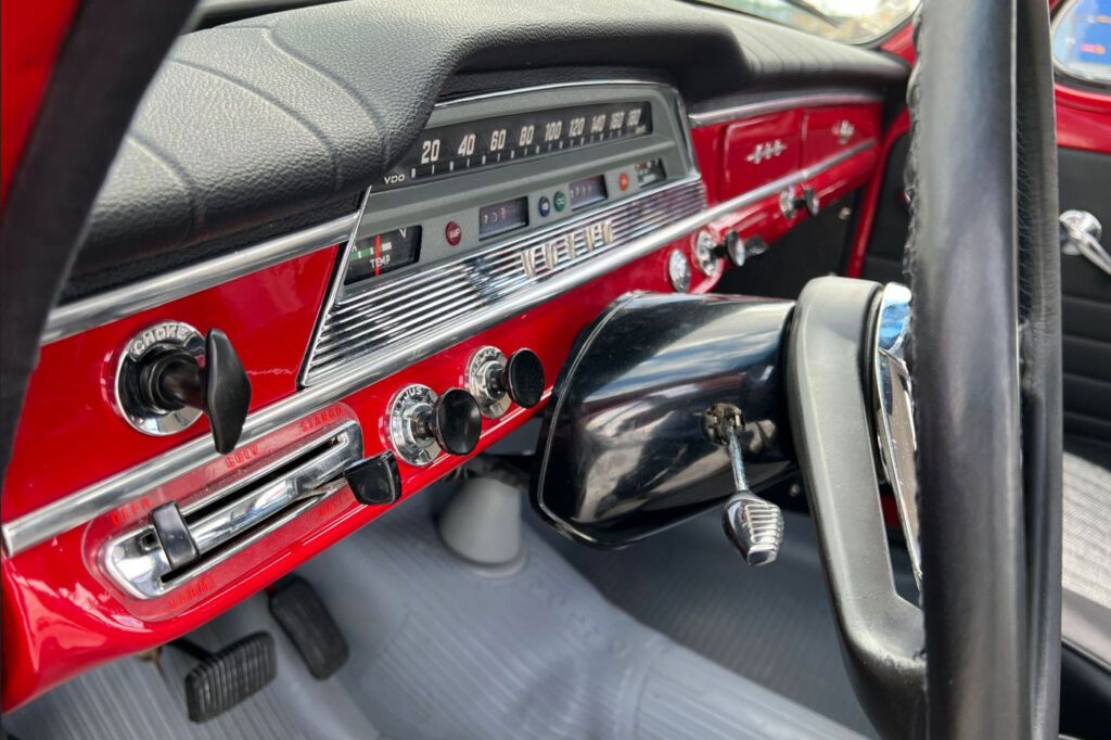 The restored dashboard in the car which is painted in matching red