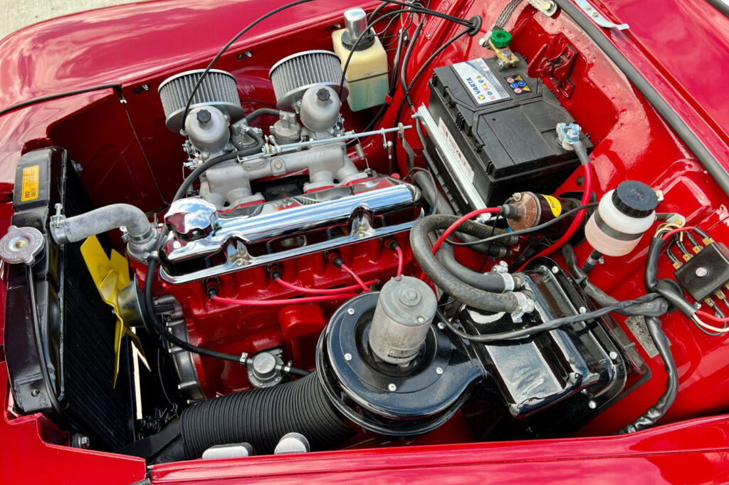 A close up view of the cars engine showing the chrome elements