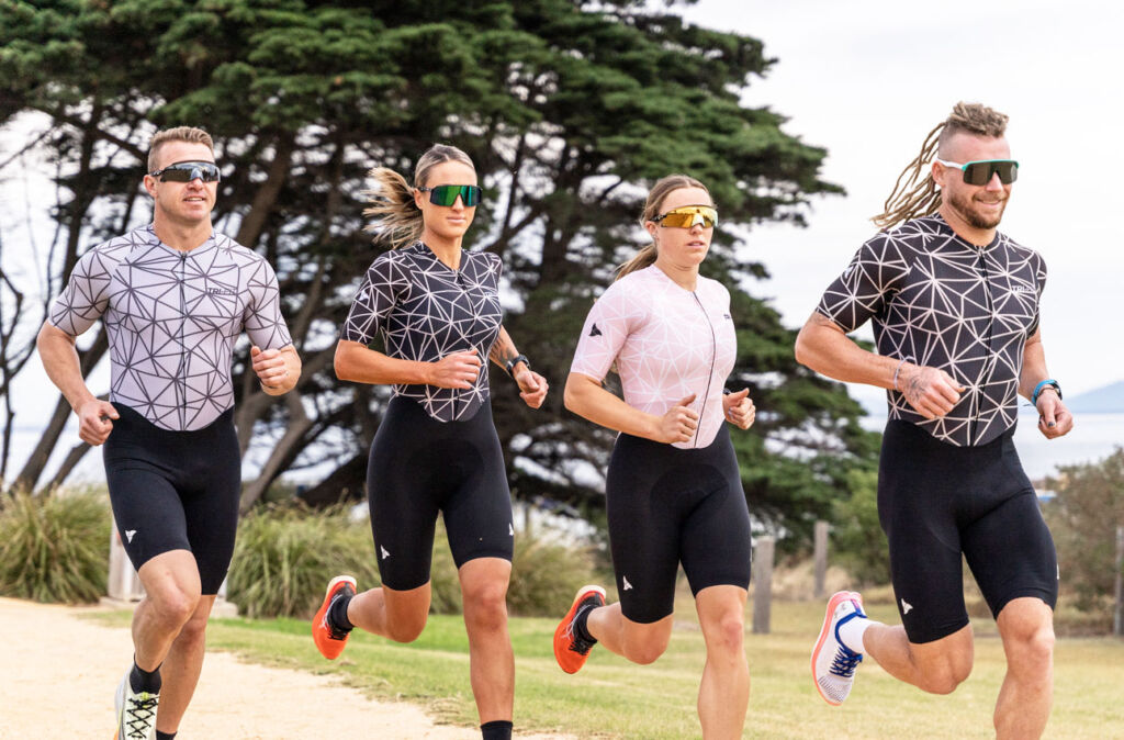 Male and female athletes running in the brand's tri-suits