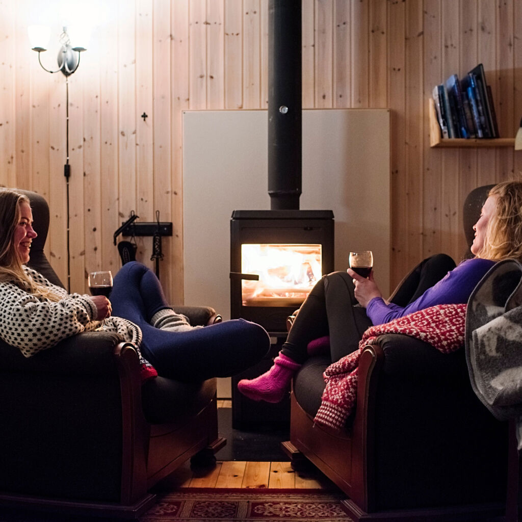 Two ladies relaxing in the cabin in front of the heating stove