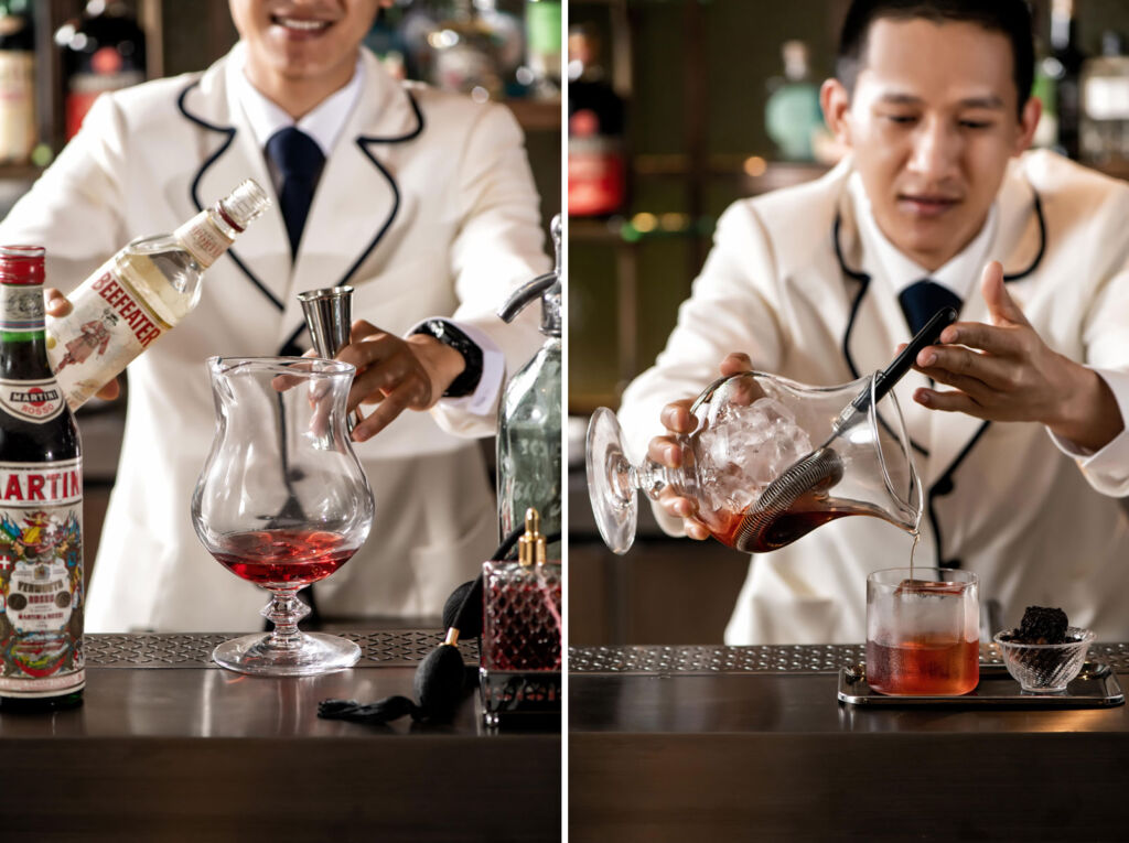 A member of the bar staff making a huge cocktail in an oversized glass