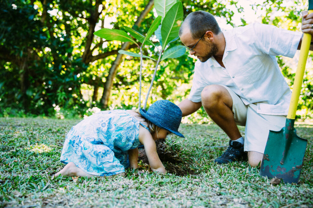 A father and daughter having fun planting trees