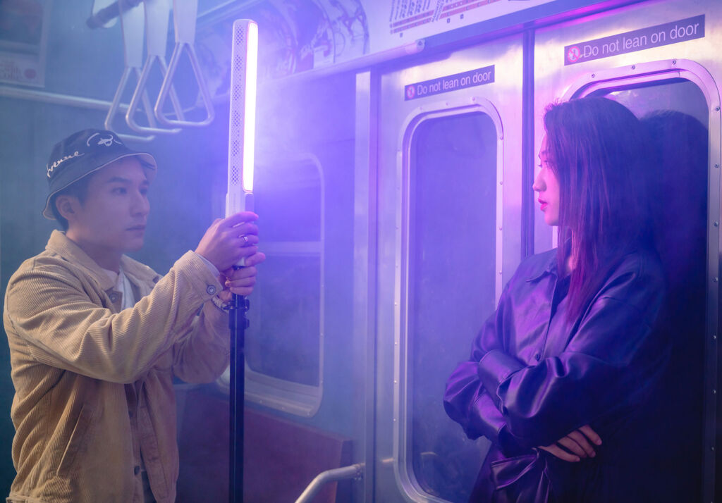 A photographer lighting the interior of a subway train with the ZHIYUN light stick