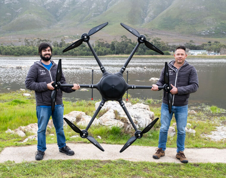 Company representatives either side of the giant drone