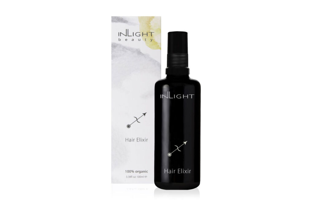 A bottle of Inlight Beauty Hair Elixir next to its box