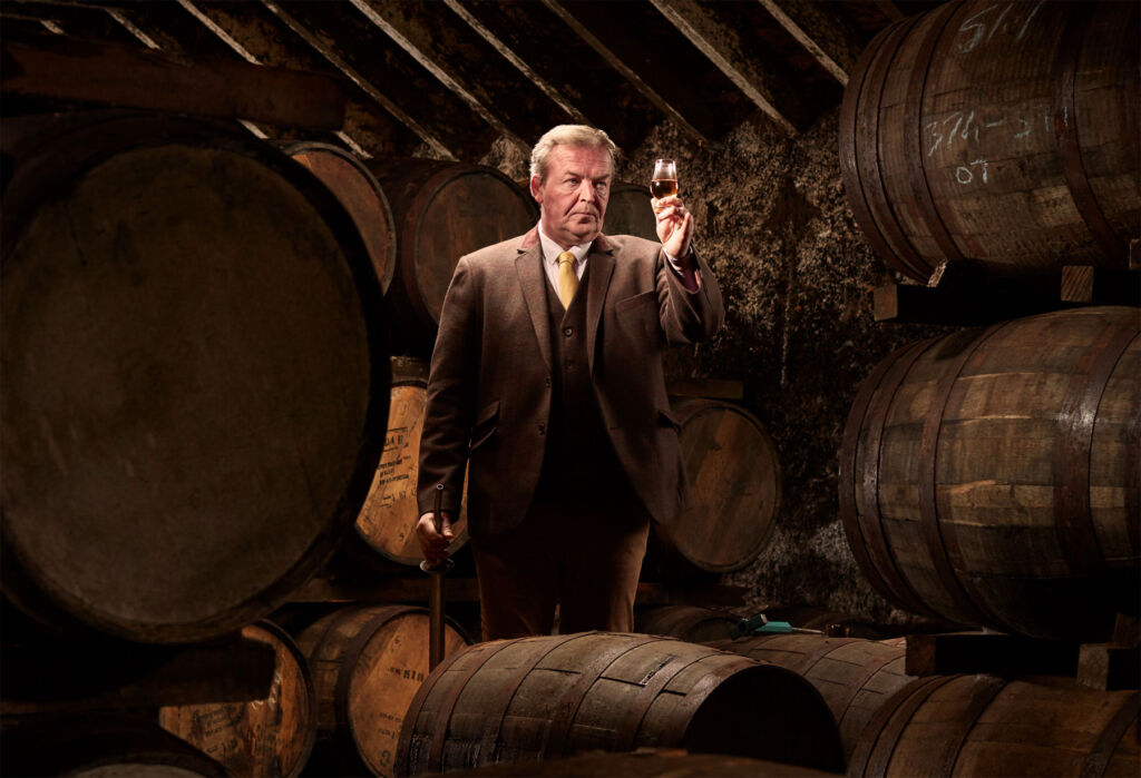 John, lost in thought amongst the barrels of whisky 