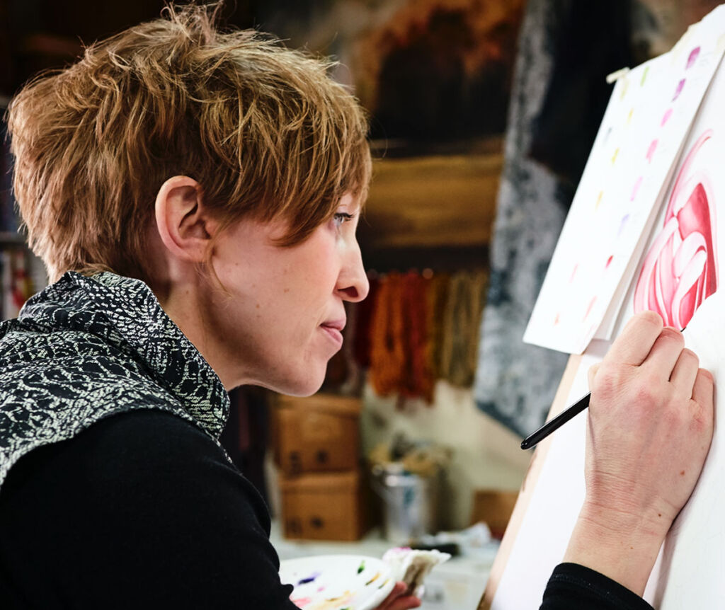 Lorraine Breger using watercolours to work on a design in her studio