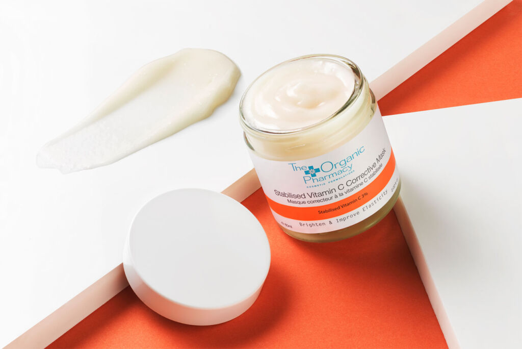 An open jar of Organic Pharmacy Stabilised Vitamin C Corrective Mask with some of the cream smeared on a counter top