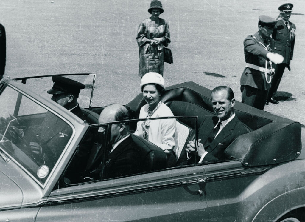 HM Queen Elizabeth II and HRH Prince Philip in an open top car on a tour