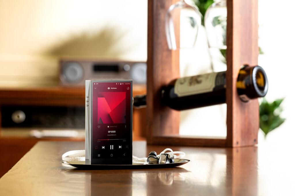 Astell&Kern's music player on a table with a bottle of wine in the background