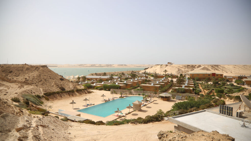 An aerial view showing the inviting turquoise swimming pool in the desert sands