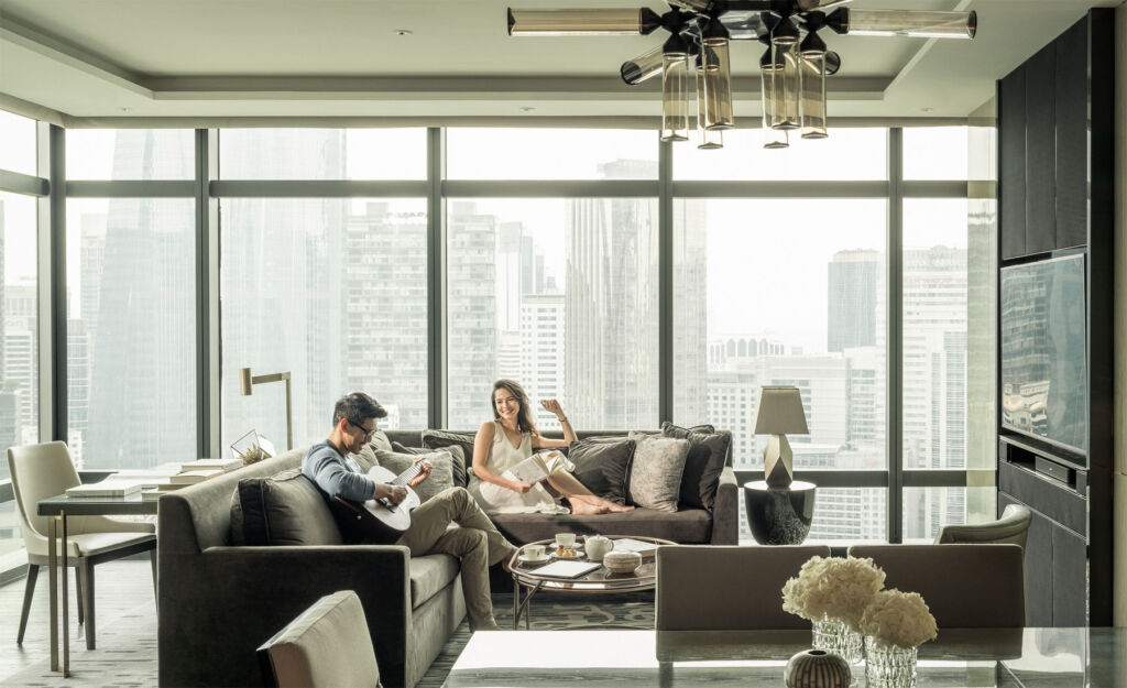 A couple enjoying some downtime in their suite enjoying the incredible views over the city