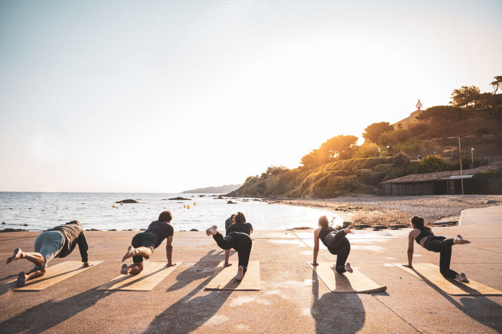 A group of people practicing yoga on the shoreline
