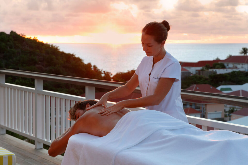 A guest having a sunset massage at the hotel on the balcony