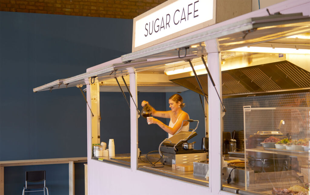 A woman pouring a freshly brewed coffee in the Sugar Cafe