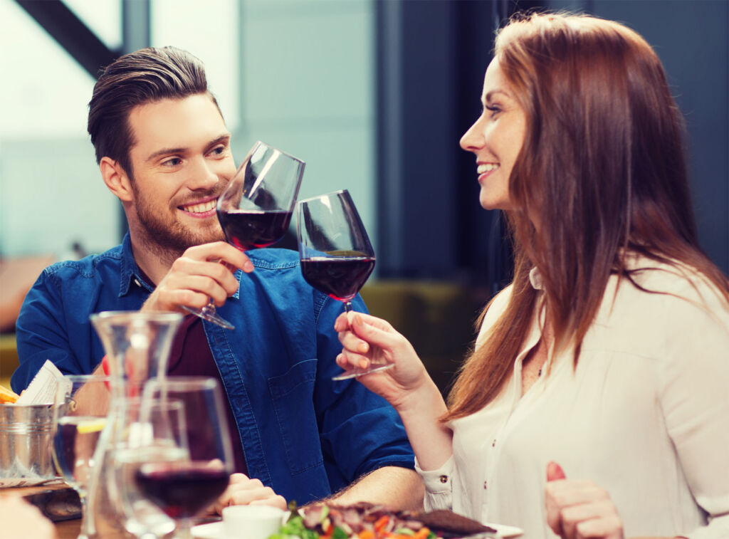 A young couple enjoying glasses of red wine
