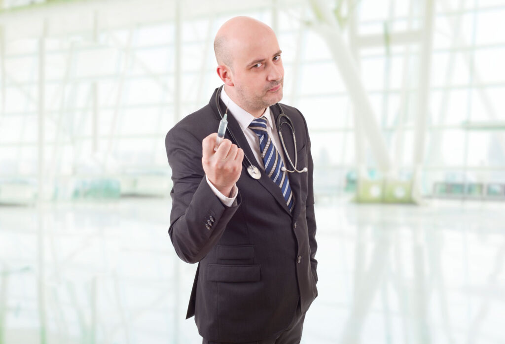 A male doctor holding a syringe in its hand
