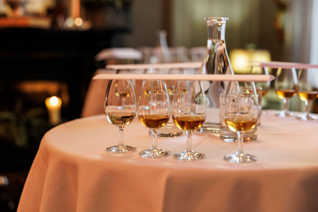 The glasses of whiskey on a linen covered table ready to be tasted