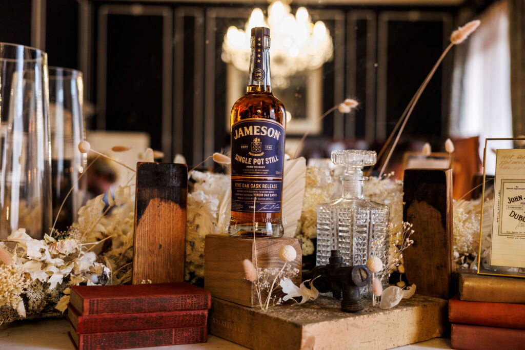 A bottle of the whiskey on a wooden block surrounded by items from the historic property where the launch took place