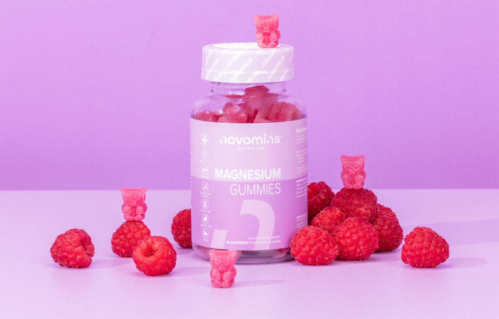 A jar of Novomins Magnesium Gummies with some of the bears outside the bottle