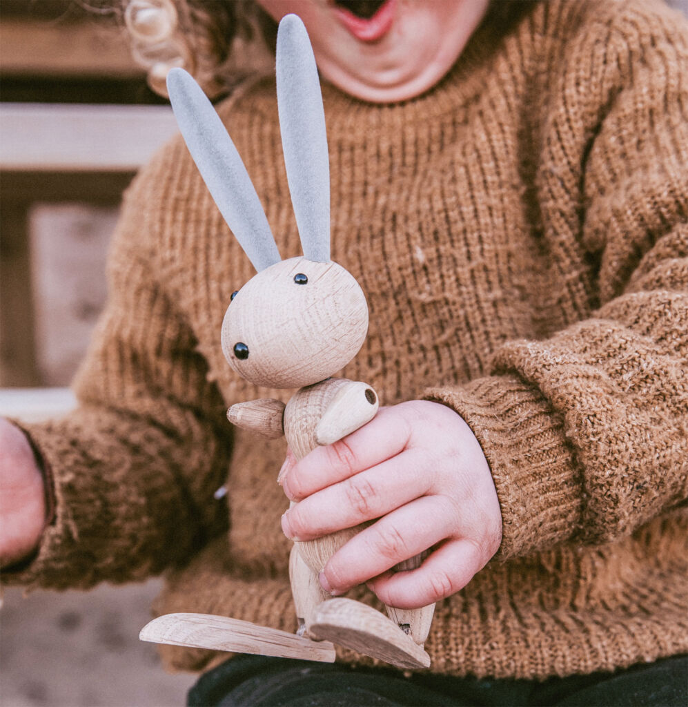 A young boy holding the wooden rabbit