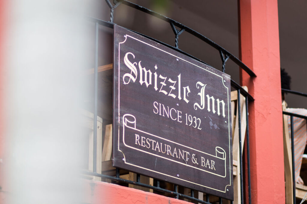 The wooden sign hanging outside the Swizzle Inn