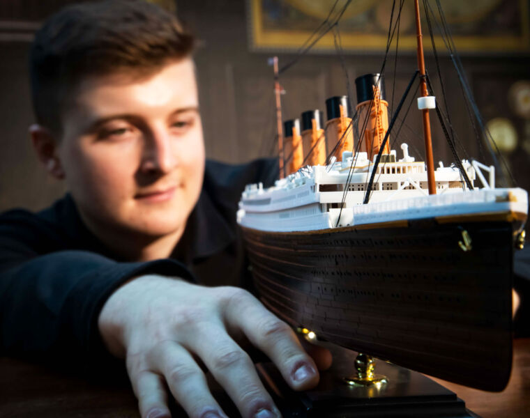 A young man admiring a model ship