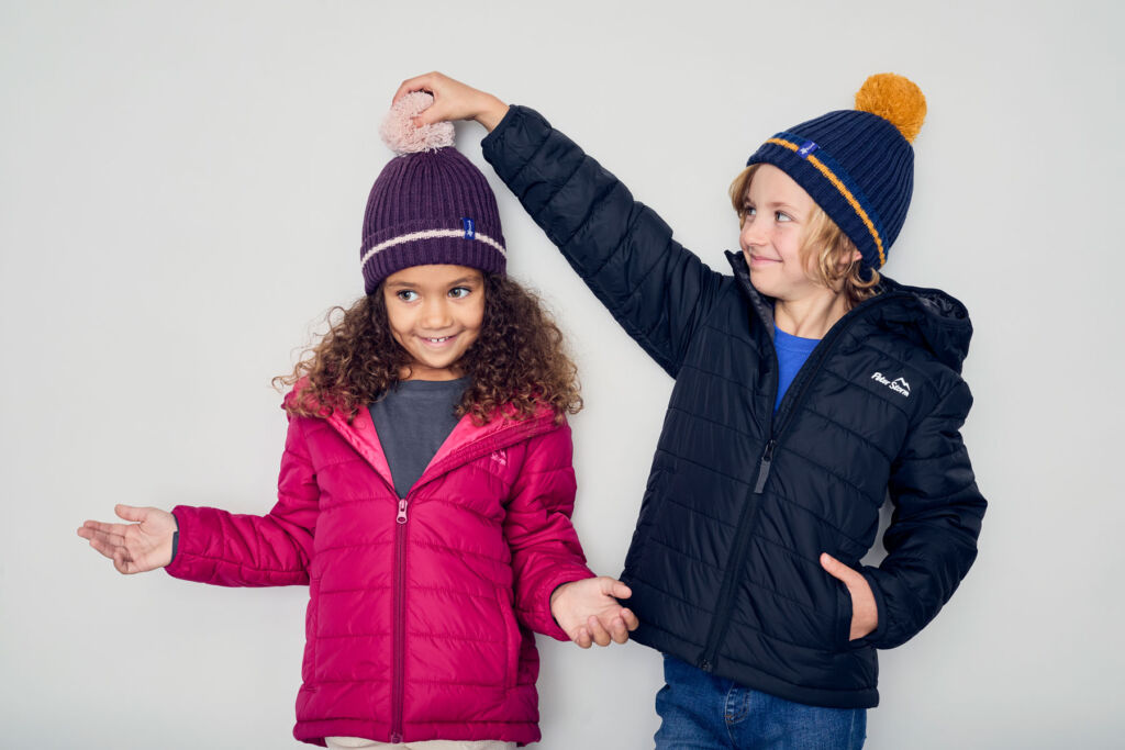 Two children wearing the charity bobble hats