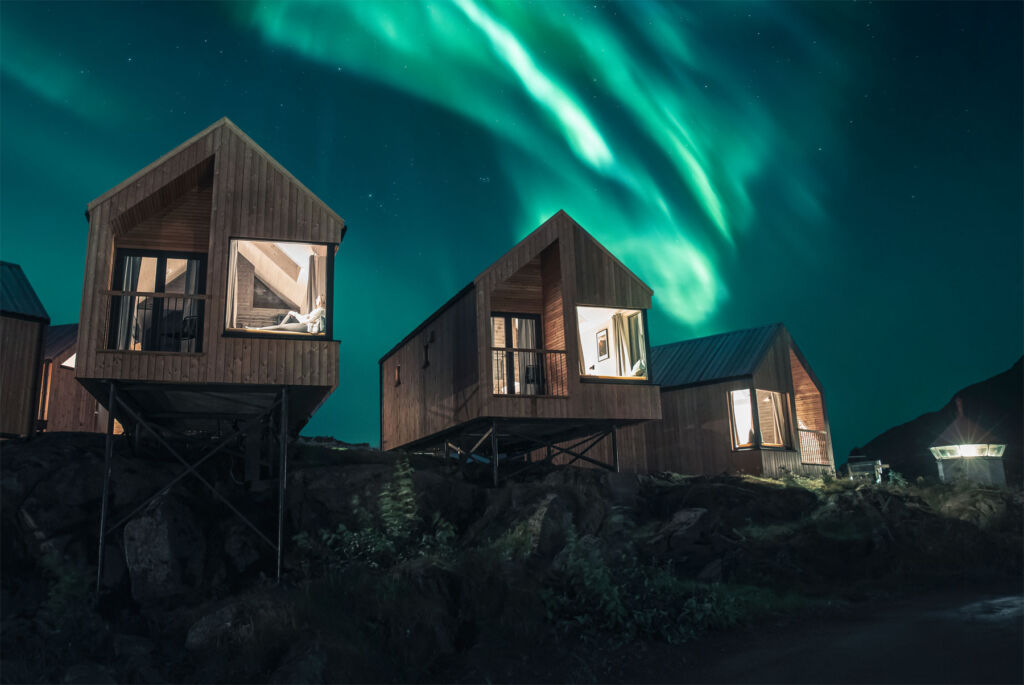 Three of the restored fishermen's huts under the Northern Lights (Aurora Borealis)