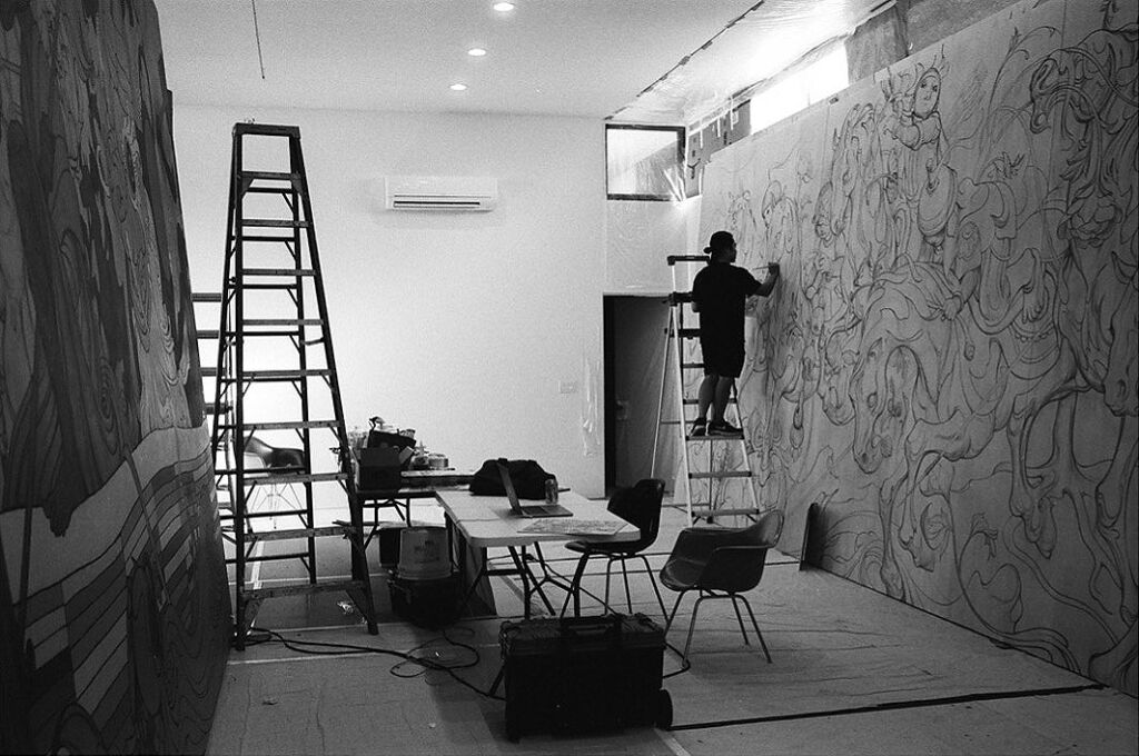 A black and white image showing the artist at work
