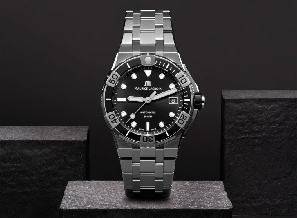 One of the new models with a black dial and steel strap on a granite block