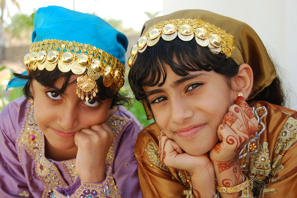 Two young Omani girls resting their chins on their hands