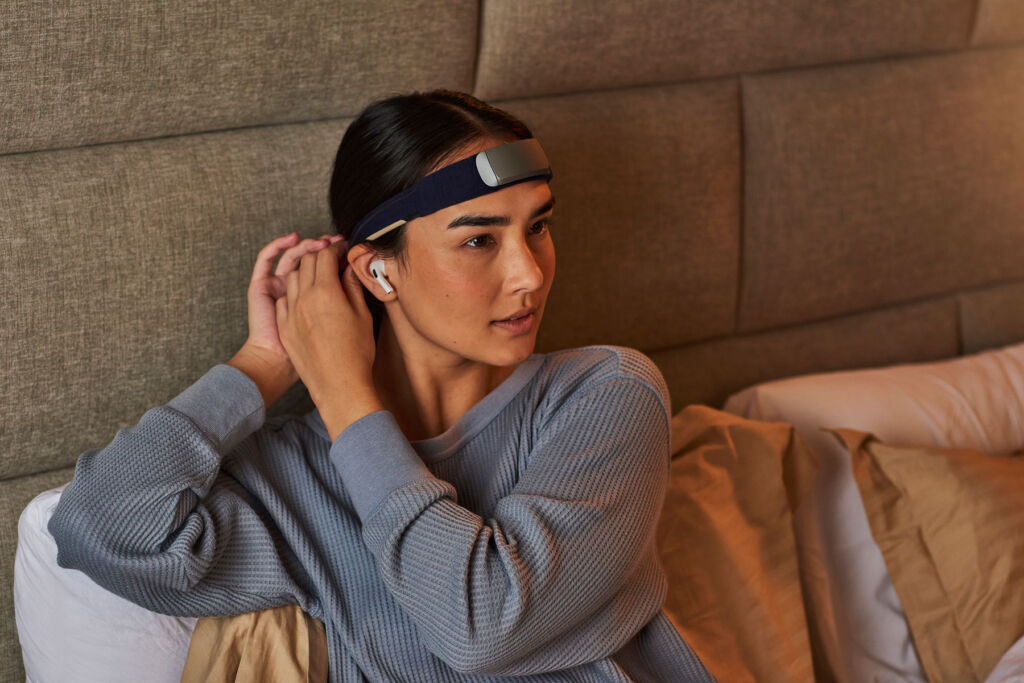 A woman adjusting the headband while sat in bed