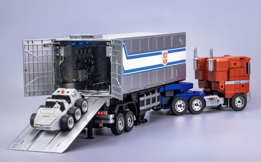 The trailer connected to Optimus Prime with Spike driving his vehicle out of the rear