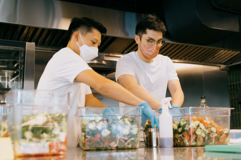 Two young men sorting through fresh vegetables, which will be given to those in need