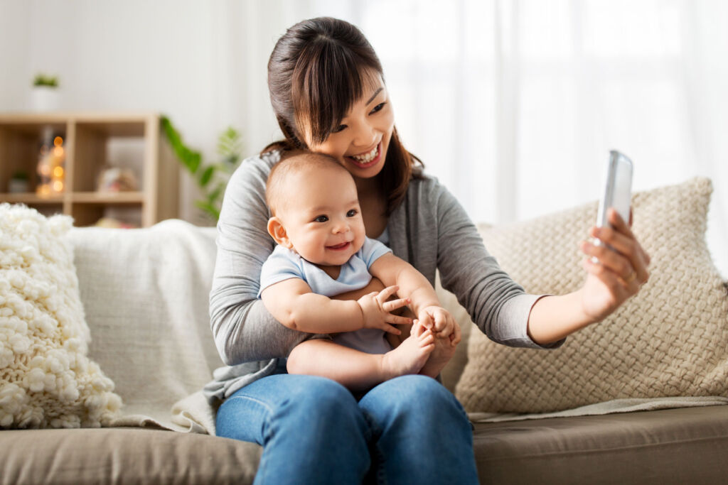 A woman introducing her baby to friends via a video call