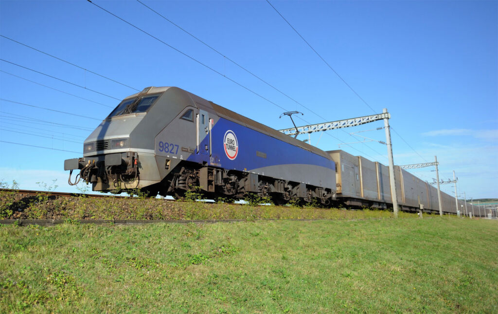 The electric train travelling on day with bright blue sky