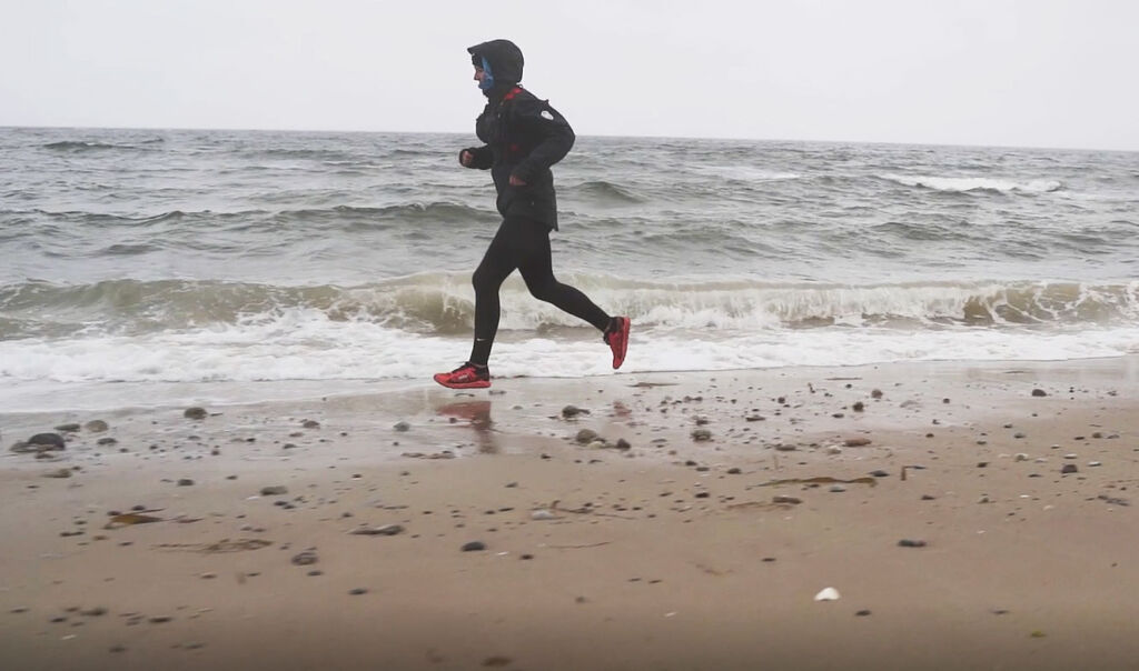 A female competitor running on the beach