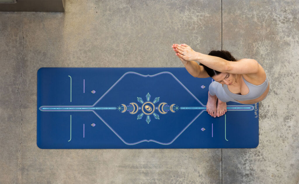 A top down view of a yoga devotee practicing a pose on the new mat