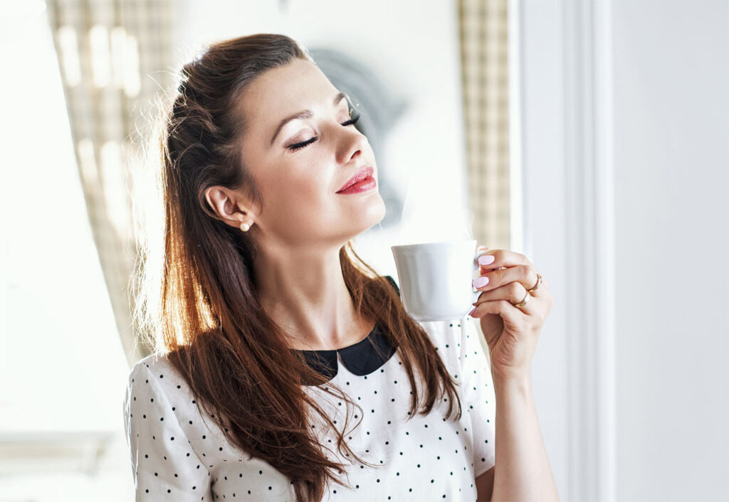 A young woman enjoying drinking a cup of tea