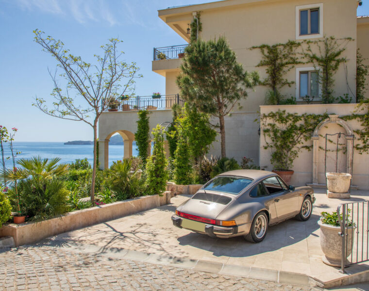 A classic Porsche sports car parked outside Villa Ponta Melagrana in Pržno