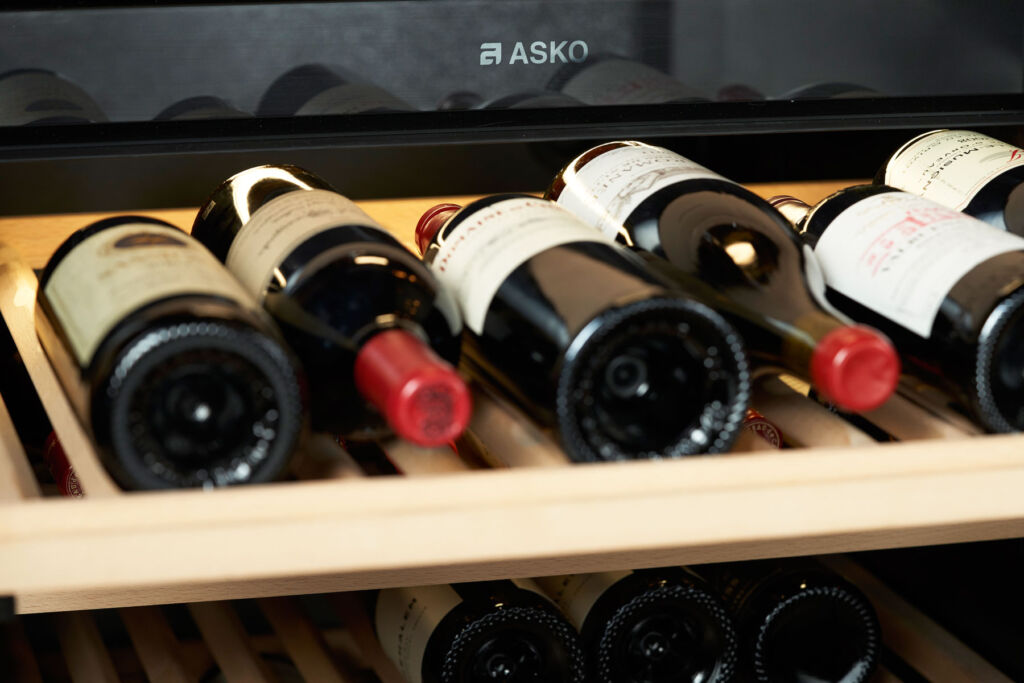 A selection of quality red wines laid next to each other on a wine cabinet rack