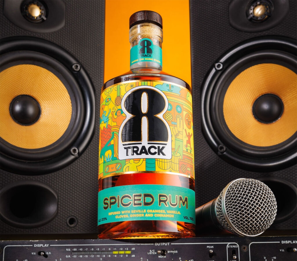 A bottle of the spiced rum between speakers, with a microphone