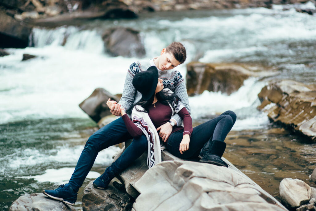 A young couple next to a fast flowing river